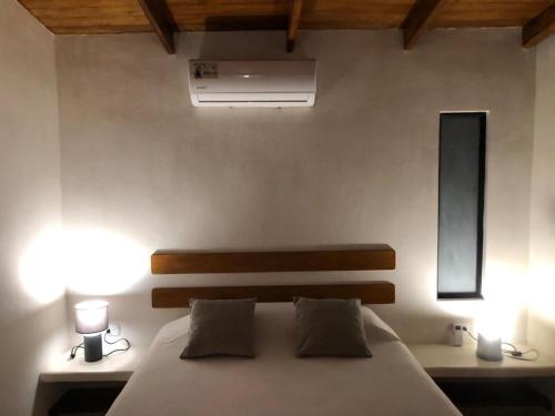 a bedroom with a large bed with two lights on it at Hotel Luz de Luna in Santa Teresa Beach