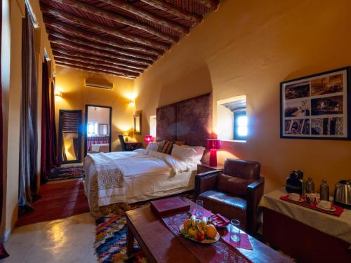 a bedroom with a bed and a table and a chair at Kasbah Agafay Hotel & Spa in El Karia