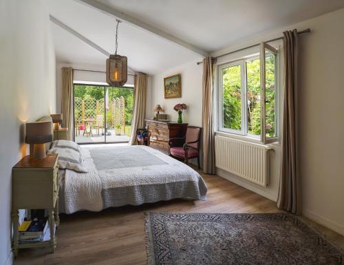 a bedroom with a bed and a desk and a window at Authentique Maison familiale en Périgord Pourpre in Lembras
