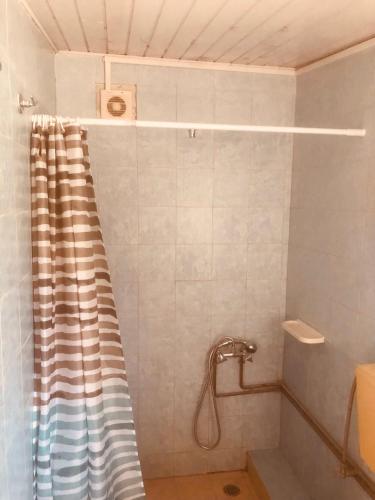 a shower with a striped shower curtain in a bathroom at Barreira Beachfront Rooms 6 in Kalamata