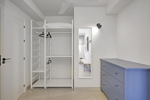 ein weißer Schrank mit einer blauen Kommode und einem Spiegel in der Unterkunft NUEVO piso centro Torre del Mar in Torre del Mar