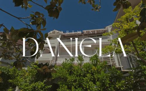 a sign for a building with trees in the foreground at Apartmani Daniela in Rab
