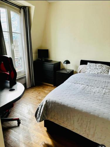 une chambre avec un lit, un bureau et une fenêtre dans l'établissement Quiet appartment, à Paris
