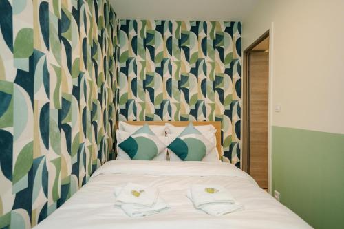 une chambre avec un lit avec deux serviettes dessus dans l'établissement Parisian Elegance Wood near Bastille and Marais, à Paris