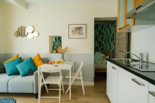 une cuisine et un salon avec une table et un canapé dans l'établissement Parisian Elegance Wood near Bastille and Marais, à Paris