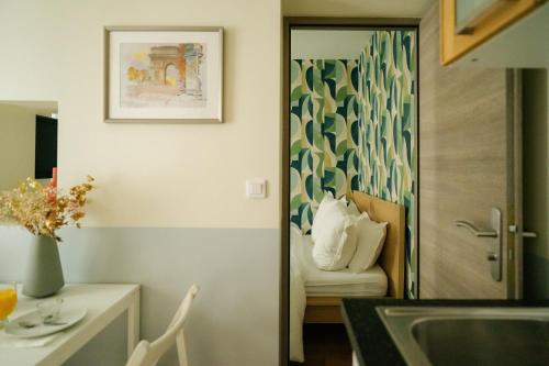 une cuisine avec une porte menant à une pièce avec un canapé dans l'établissement Parisian Elegance Wood near Bastille and Marais, à Paris