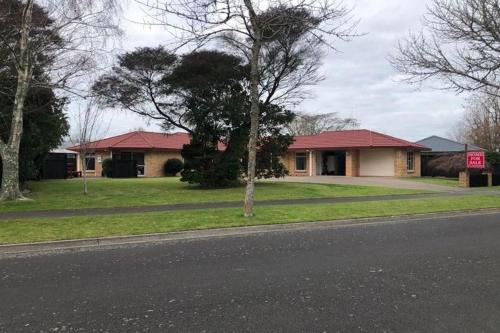 a house on the side of a street with a sign at Quiet and comfortable in Hamilton