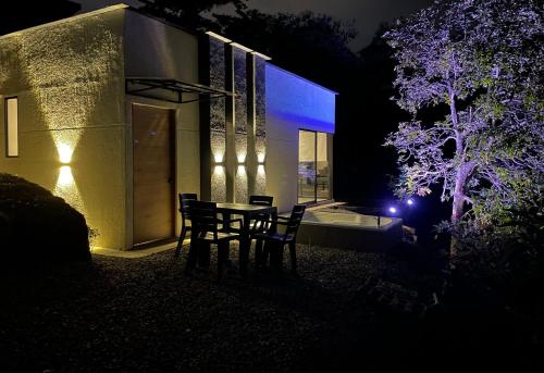 a table and chairs in front of a house at night at Glamping Galcano in Dosquebradas