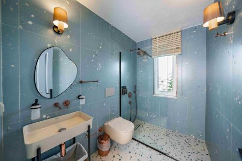 a blue bathroom with a toilet and a sink at Alya Country in Turunc