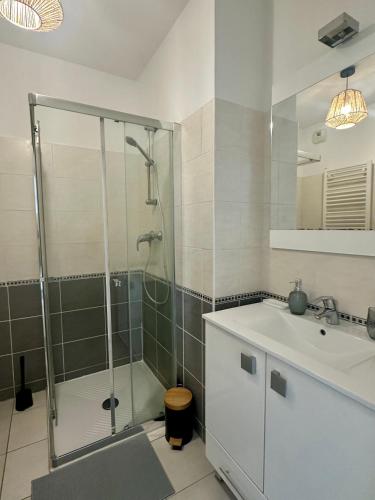 une salle de bain avec douche et lavabo dans l'établissement Cosy studio avec parking et vue féerique, à Nice