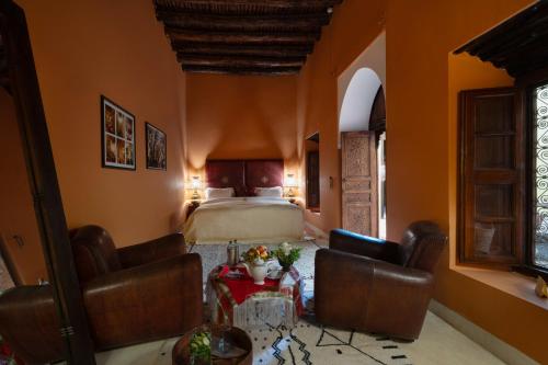 a bedroom with a bed and a table and chairs at Kasbah Agafay Hotel & Spa in El Karia