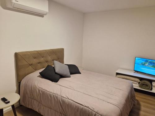 a bedroom with a bed and a flat screen tv at Excelente ubicación, nuevo, luminoso! in Montevideo