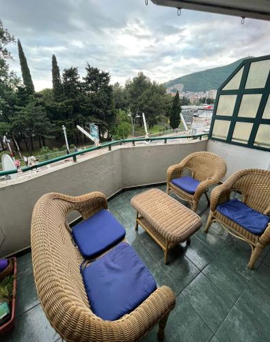 a balcony with two chairs and wicker chairs and a table at Apartments Mare Budva in Budva