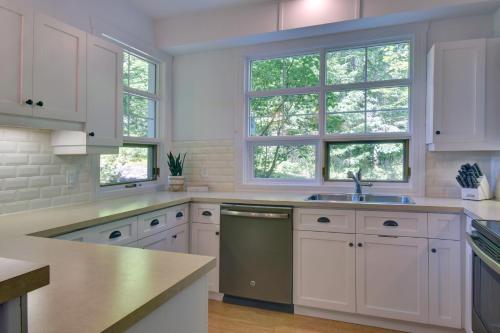 a kitchen with white cabinets and a sink and windows at Tremblant Prestige - Les Eaux 227-6 in Mont-Tremblant