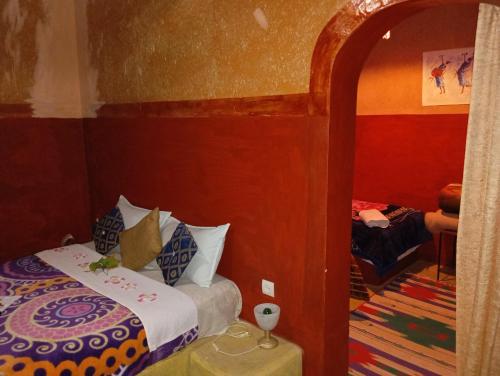 a small bedroom with a bed and a mirror at Kasbah tifaoute ait Ben haddou in Aït Ben Haddou