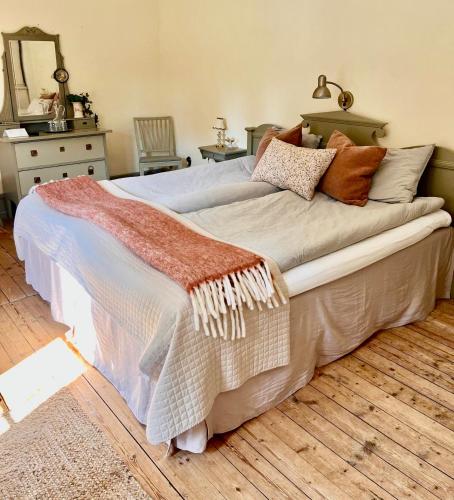 a bedroom with a large bed with pillows on it at Lydde Gård in Kinna