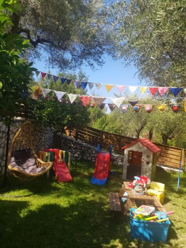 a backyard with a table and chairs and a play area at MARATHES STUDIOS in Agios Nikitas