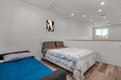a bedroom with two beds and a window at Modern 1-Bedroom Loft in Hollywood with Parking, WiFi & Hollywood Sign View in Los Angeles