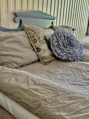 a bed with a blue headboard and pillows on it at Lydde Gård in Kinna