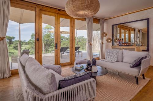 a living room with a couch and a table at JW Marriott Masai Mara Lodge in Masai Mara