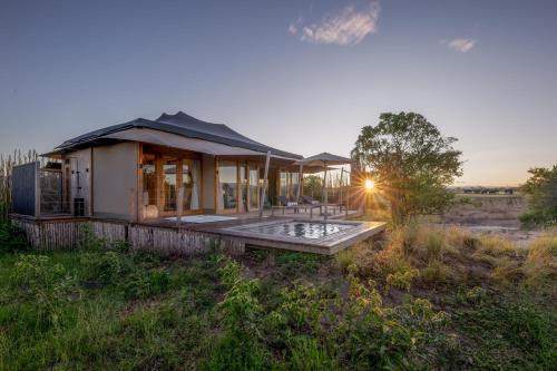 a house in the middle of a field at JW Marriott Masai Mara Lodge in Masai Mara