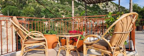 a balcony with two chairs and a table and flowers at Villa Porta Qeparo in Qeparo