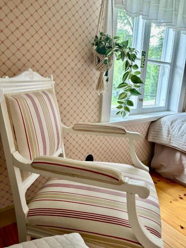 a white chair in a room with a window at Lydde Gård in Kinna