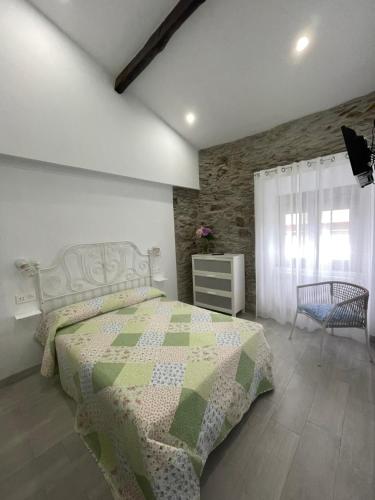 a bedroom with a bed with a green and white quilt at CASA SANTI Y LAURA in Cudillero