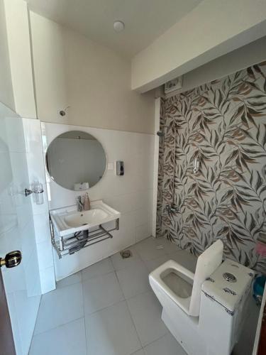 a bathroom with a sink and a toilet and a mirror at Summit Resorts (Republika Central) in Abbottabad