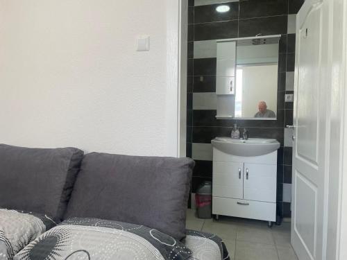 La salle de bains est pourvue d'un canapé, d'un lavabo et d'un miroir. dans l'établissement Villa Lira, à Ohrid