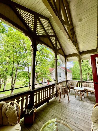 a large screened in porch with chairs and a table at Lydde Gård in Kinna