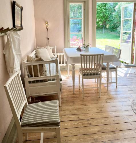 a dining room with a white table and chairs at Lydde Gård in Kinna
