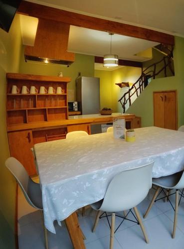 a dining room with a white table and chairs at La Rueda del Chucao in Valdivia