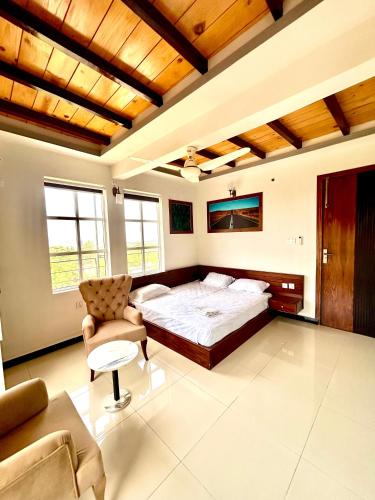a large bedroom with a bed and a chair at Republika Central Hotel & Resort in Abbottābād