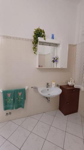a white bathroom with a sink and a mirror at casa vacanze Luisa in Lazzeretto