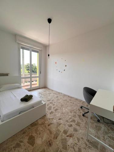 a bedroom with a bed and a desk and a chair at mirabello in Reggio Emilia