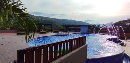 a large swimming pool with a water fountain at Apartamentos de lujos para descansar Oasis in San Jerónimo