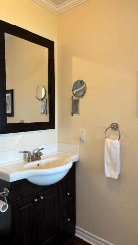 a bathroom with a sink and a mirror at Seascape Coastal Retreat - 2 ADULTS ONLY - HOT TUB AND WITHOUT HOT TUB OCEANFRONT PROPERTY in Ingonish