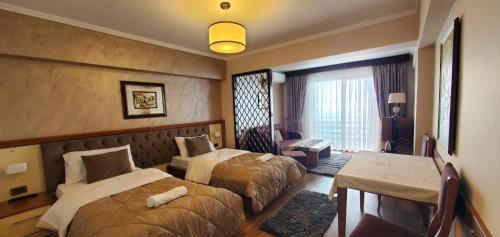a hotel room with two beds and a desk at Hotel Panorama Dajt in Tirana