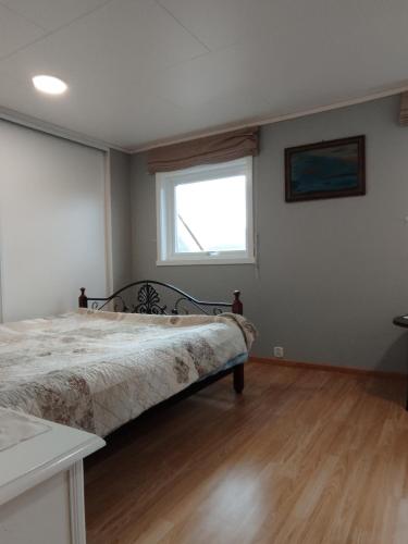 a bedroom with a bed and a window at Sveciu namai in Vikedal