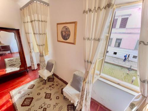 a living room with a window and a chair at L'ENCANTO DE LUNA -Una Casa Autentica Comacchiese in Comacchio