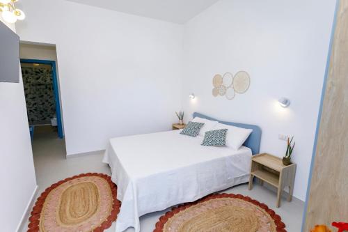 a white bedroom with a bed and a table at Villa Rebecca in Nardò