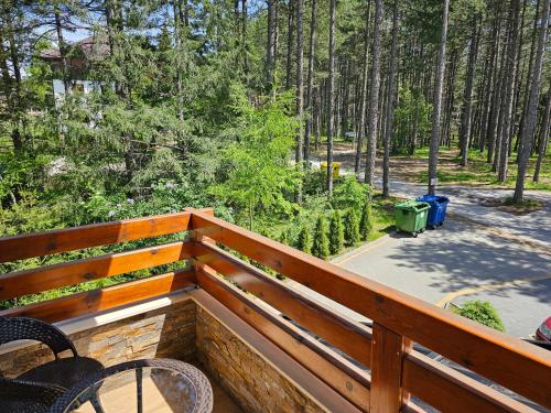 a balcony with chairs and a view of a forest at Apartman Pineta in Zlatibor
