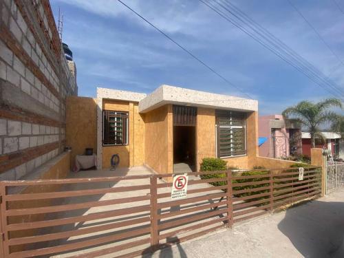 a small house with a fence in front of it at Casa Hogar Feliz in San Juan de los Lagos