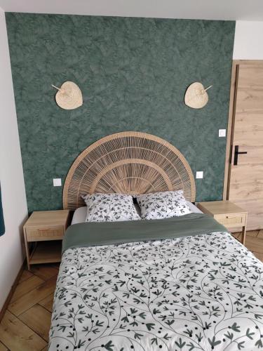 a bedroom with a large bed and a green wall at La rose des vents in Fécamp