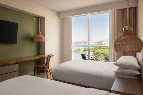a hotel room with two beds and a window at Santa Marta Marriott Resort Playa Dormida in Santa Marta