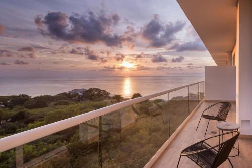 a balcony with two chairs and a view of the ocean at Santa Marta Marriott Resort Playa Dormida in Santa Marta