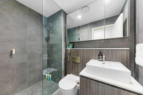 a bathroom with a toilet and a sink and a shower at City views & New 3b2b1p Apt in Homebush in Sydney
