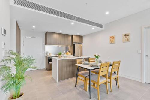 a kitchen and dining room with a table and chairs at City views & New 3b2b1p Apt in Homebush in Sydney