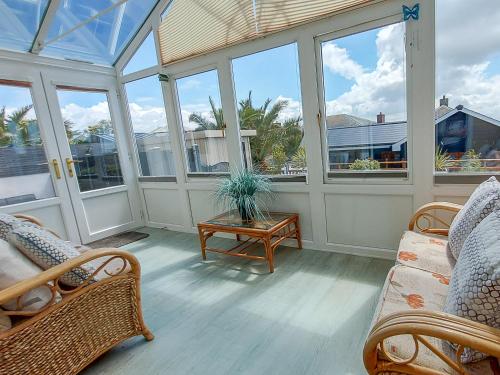 a screened in porch with chairs and a table at Meadow View Apartments in Newquay